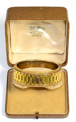 Lot 182 - A Victorian bangle, the front with a hexagonal motif, to rope borders, on a plain hinged back,...
