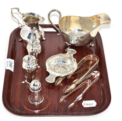 Lot 246 - A George III silver cream jug, a silver sauceboat, a silver tea strainer, four pairs of silver...