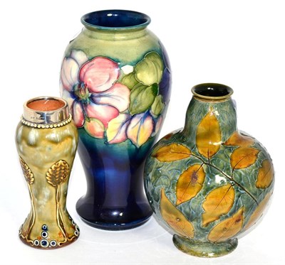Lot 254 - A Moorcroft Anemone pattern vase, a Doulton vase and another with a silver mount