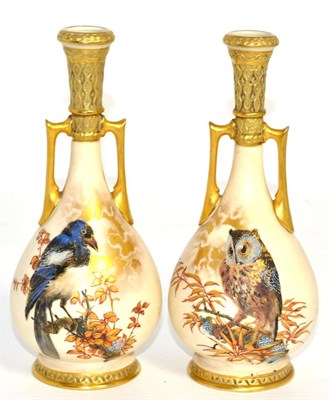 Lot 256 - A pair of Royal Worcester blush ivory twin handled vases, decorated with birds
