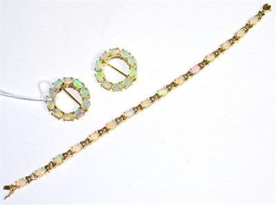 Lot 298 - A 14 carat gold opal bracelet, oval cabochon opal links spaced by X-shaped links, length 18cm...