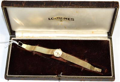 Lot 304 - A lady's 9 carat gold Longines wrist watch, on an integral 9 carat gold strap, cased