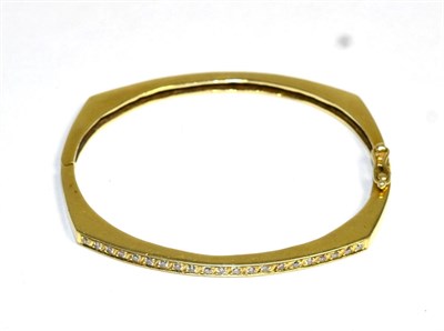 Lot 399 - A diamond bangle, an angular hinged bangle with a central band of round brilliant cut diamonds,...