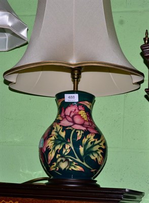 Lot 488 - A Moorcroft table lamp decorated with pink flowers on a green ground, 28cm (excluding fitting)