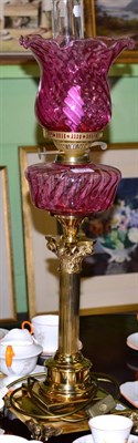 Lot 497 - A reproduction cranberry glass and brass table lamp, in the form of an oil lamp (converted)&nbsp