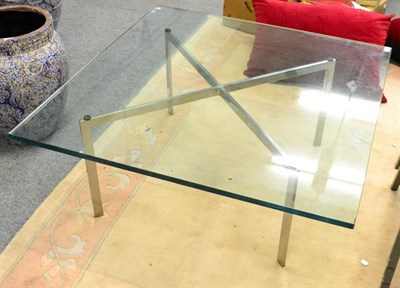 Lot 1173 - A glass top coffee table, of square form, raised on square tubular polished metal legs, 101cm...