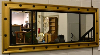 Lot 1180 - A Regency style parcel gilt sectional mirror with black painted slip