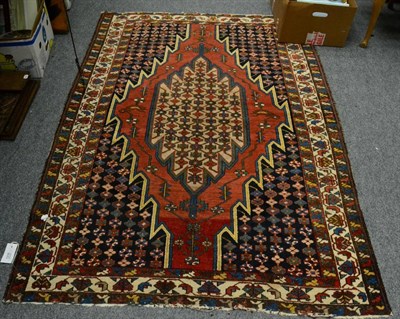 Lot 1216 - Mazlaghan rug, West Iran, the madder field with camel lozenge enclosed by spandrels and ivory...