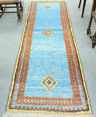 Lot 1226 - Gabbeh runner, South West Iran, the sky blue field with three stepped medallions framed by...