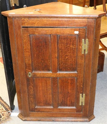 Lot 1323 - An oak four panelled corner cupboard