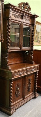 Lot 1327 - A Victorian carved oak cabinet,the glazed upper section above a recess, over two drawers and...