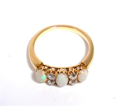 Lot 90 - An opal and diamond ring, three oval cabochon opals, spaced by pairs of old cut diamonds, total...