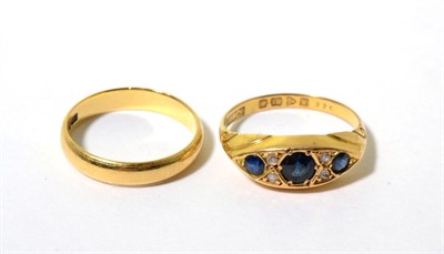Lot 115 - An 18 carat gold sapphire and diamond ring, three graduated round cut sapphires, spaced by...