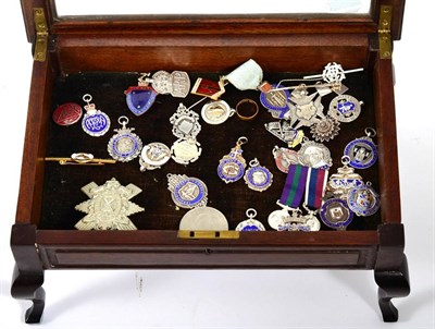 Lot 184 - A collection of silver, base metal and enamel medals and badges, including: a silver ARP badge;...