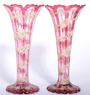 Lot 187 - A pair of Bohemian cranberry flash glass vases decorated with gilt and painted floral vines