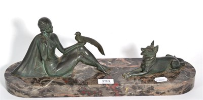 Lot 233 - An Art Deco figure of a seated girl with bird and recumbent dog, on a marble base