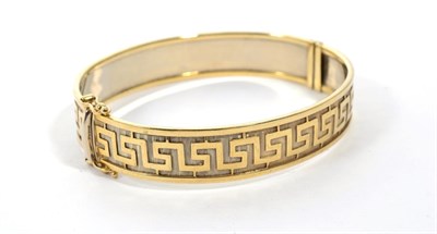 Lot 289 - A 9 carat gold Greek key motif bangle, measures 6cm by 5.5cm