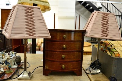 Lot 1002 - A small mahogany inlaid bow fronted chest of drawers and a pair of table lamps with shades