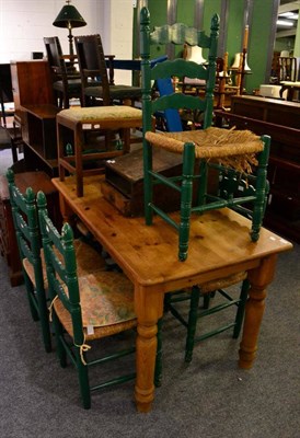 Lot 1113 - A pine kitchen table together with six green painted rush seated dining chairs (7)