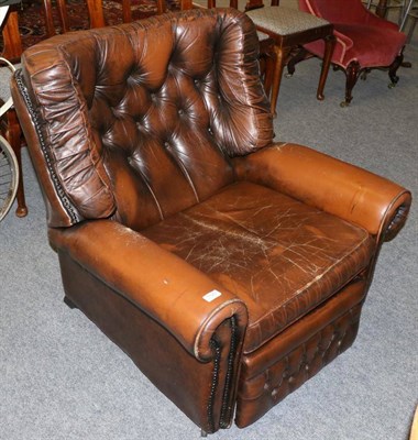 Lot 1129 - A brown leather button back reclining armchair