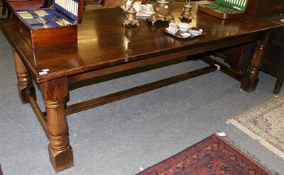 Lot 1260 - A large oak refectory dining table, raised on massive block feet, one carved with a rose