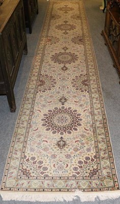 Lot 1291 - Narrow Oriental runner, the ivory field with a column of flowerheads enclosed by narrow...