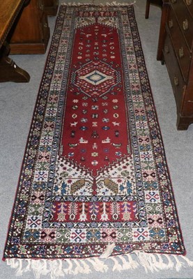 Lot 1300 - Narrow Moroccan runner, the raspberry field with central medallion framed by compartmentalised...