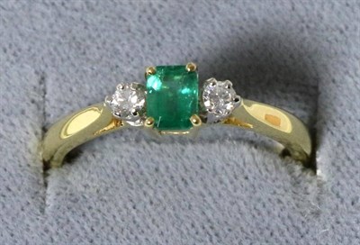 Lot 29 - An 18 carat gold emerald and diamond three stone ring, an octagonal cut emerald, spaced by...