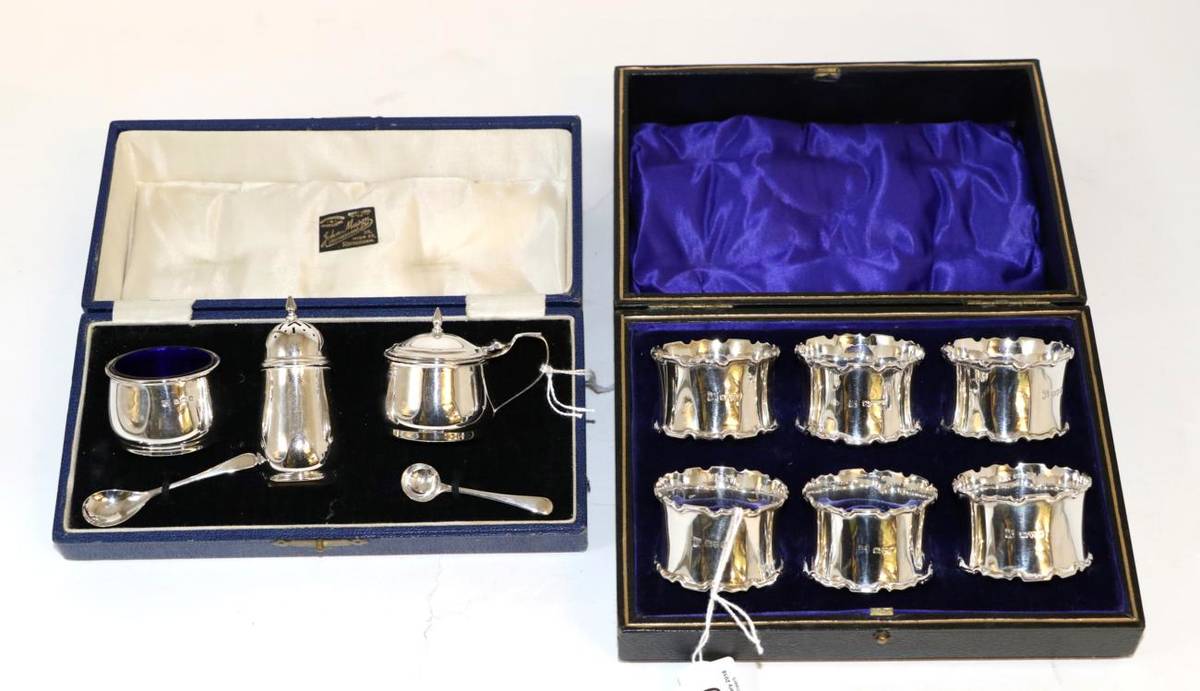 Lot 120 - A set of six silver napkin rings, Chester 1922, in a fitted case; and a silver three piece...