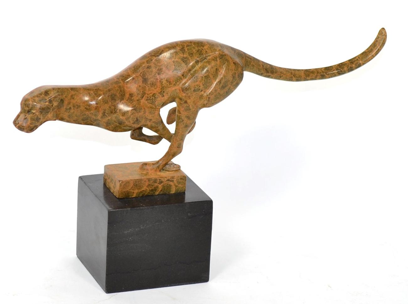 Lot 202 - A modern patinated bronze cheetah, in a running pose, on a black marble base, 33cm wide, 19cm high