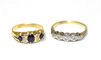 Lot 231 - An 18 carat gold sapphire and diamond ring, three oval cut sapphires spaced by pairs of old cut...