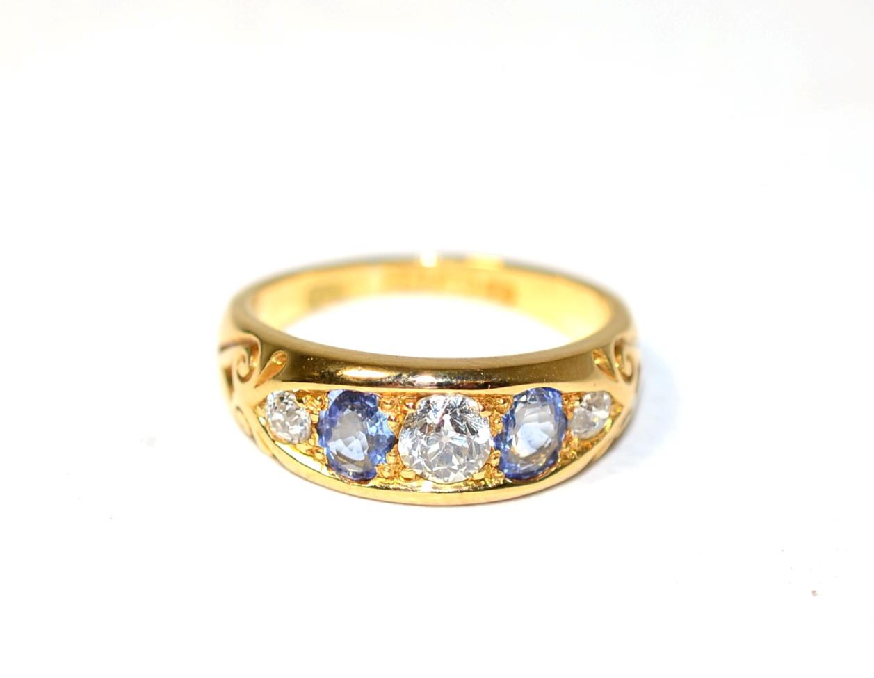 Lot 259 - An 18 carat gold sapphire and diamond ring, three graduated old cut diamonds, spaced by oval...