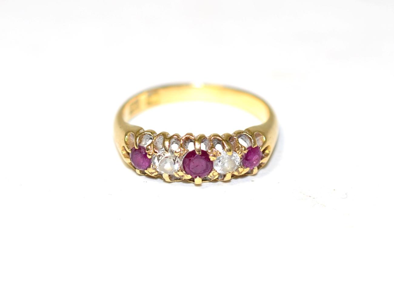 Lot 260 - A ruby and diamond ring, three round cut rubies, spaced by old cut diamonds, to a carved...