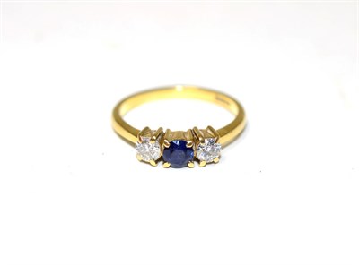Lot 263 - A sapphire and diamond three stone ring, a round cut sapphire spaced by round brilliant cut...