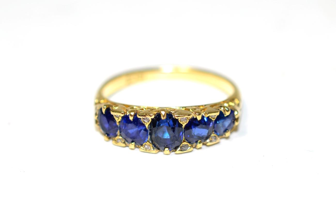 Lot 265 - A sapphire five stone ring, graduated oval cut sapphires in a carved setting, finger size M1/2,...