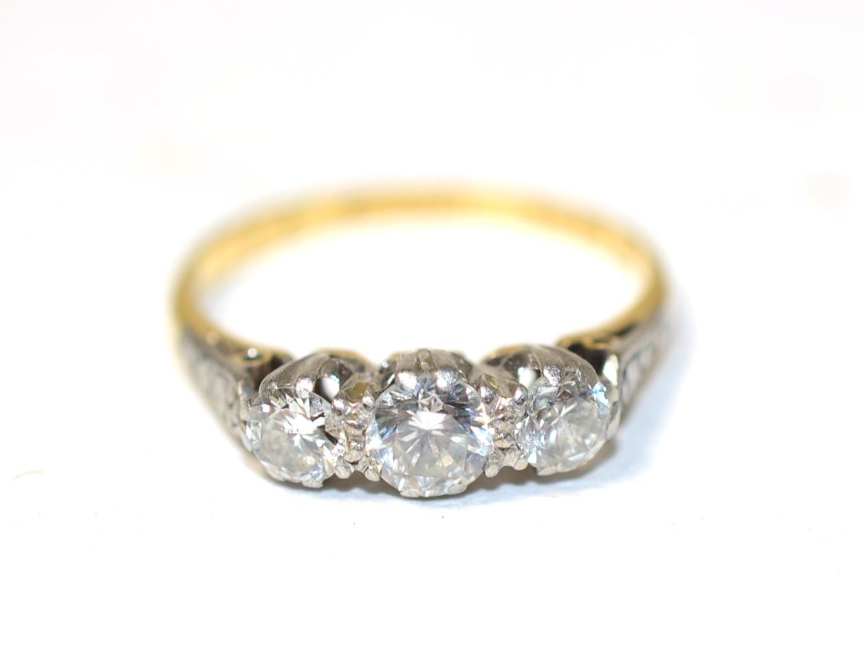 Lot 359 - An 18 carat gold three stone diamond ring, graduated round brilliant cut diamonds in claw settings