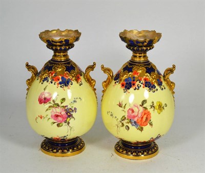 Lot 21 - A pair of Royal Crown Derby floral painted twin handled gilt highlighted vases, 22cm