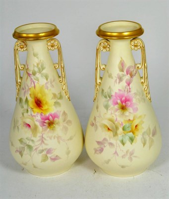 Lot 27 - A pair of Royal Worcester China Works floral painted twin handled gilt highlighted vases, 26cm