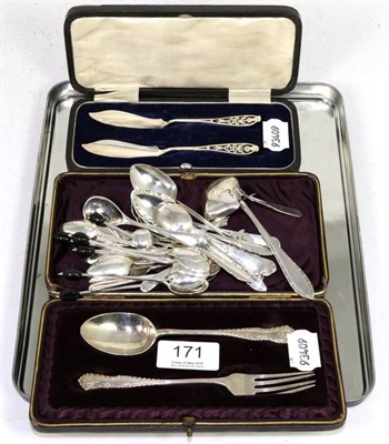 Lot 171 - A cased pair of silver fish knives with pierced thistle terminals, a cased silver christening...