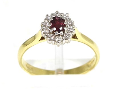 Lot 191 - An 18 carat gold ruby and diamond cluster ring, an oval cut ruby within a border of round brilliant