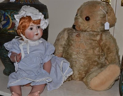 Lot 243 - A Merrythough seated teddy bear and a bisque head doll with sleeping eyes and red wig (2)