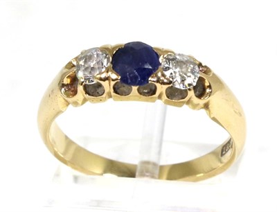 Lot 275 - A sapphire and diamond three stone ring, a round cut sapphire spaced by old cut diamonds, in a...