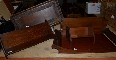 Lot 1046 - Two carved trays and three oak book racks