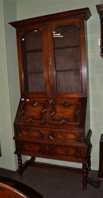 Lot 1124 - A carved oak bureau bookcase