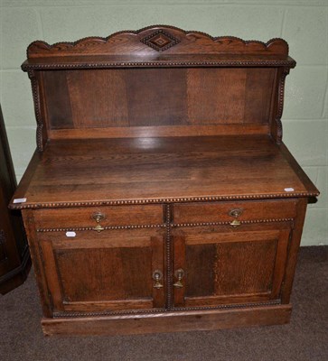 Lot 1127 - A 20th century oak low cabinet with upstand