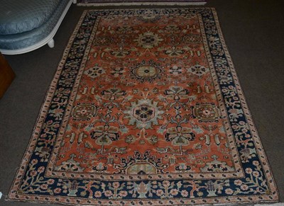 Lot 1153 - An Oriental rug of foliate design with conforming narrow borders on a terracotta ground