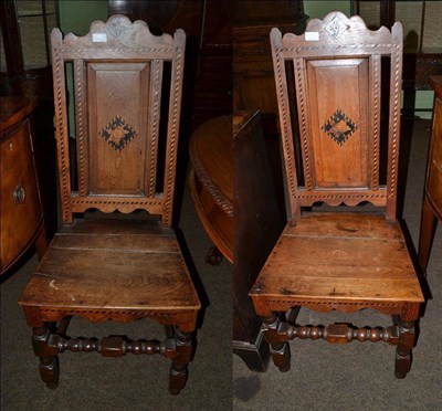 Lot 1157 - A pair of early 18th century joined oak, ebonised and parquetry decorated hall chairs, with...