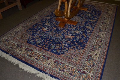 Lot 1187 - A machine made carpet of hunting design, royal blue field with central medallion framed by...