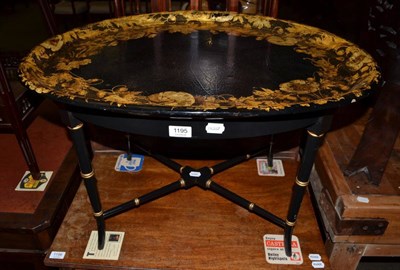 Lot 1195 - Victorian parcel gilt ebonised tray table with floral decorated papier mache tray, in the Aesthetic