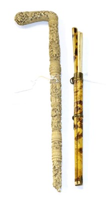 Lot 1354 - A Cantonese ivory parasol handle, circa 1880, typically carved with figures amongst trees and...